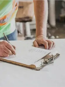 Un ouvrier de Construction HERA en train de rédiger un rapport d’inspection sur un chantier d’agrandissement de maison.
