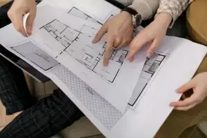 Deux personnes examinent des plans de maison — illustration de carrières en construction chez HERA.