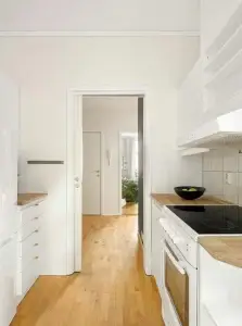 Cuisine rénovée avec comptoirs en bois clair et électroménagers blancs modernes