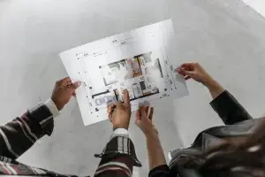 Deux personnes examinent un plan de maison – Prise de contact avec Construction HERA
