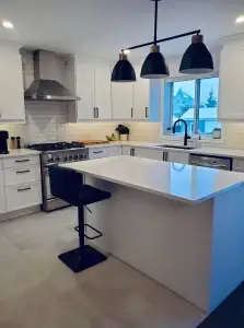 Cuisine rénovée moderne avec îlot blanc et armoires blanches – Construction HERA