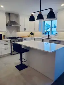 Cuisine rénovée moderne avec îlot blanc et armoires blanches – Construction HERA