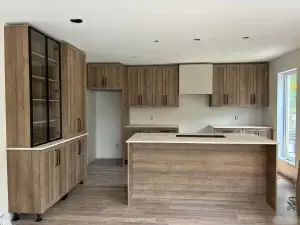 Cuisine rénovée avec armoires en bois et îlot central – Construction HERA