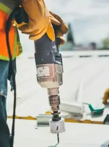 Travailleur utilisant une perceuse sur un chantier de rénovation résidentielle