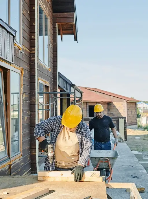 Charpentier de Construction HERA en train de percer une planche sur un chantier résidentiel au Québec
